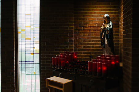 Virgin Mary statue in front of candle holders thumbnail