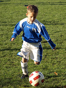boy dribbling soccer ball on soccer field thumbnail