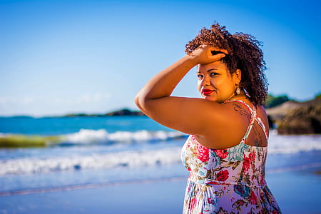shallow focus photography of woman in multicolored halter dress on seashore thumbnail