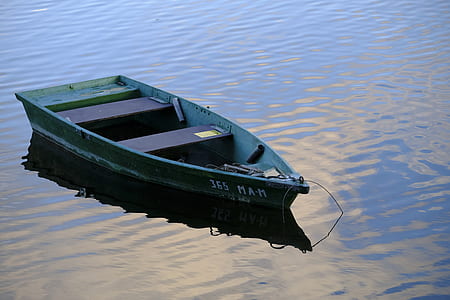 green boat floating on body of water thumbnail