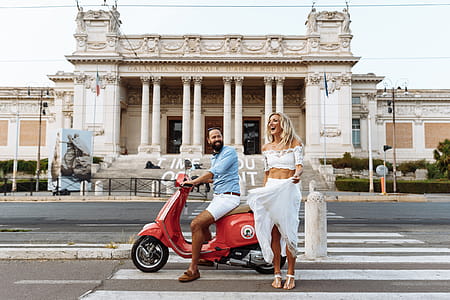 Man Riding on the Motorcycle Beside Woman Standing on the Road thumbnail