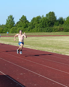 man running on track field during daytime thumbnail