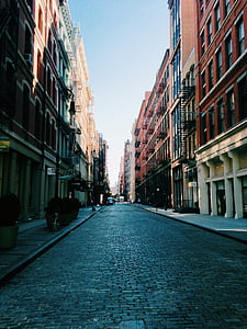 gray concrete road between buildings thumbnail
