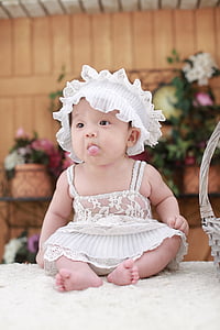 baby sitting on white table thumbnail