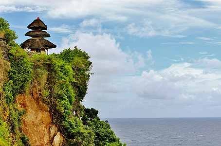 pagoda on rock formation near sea at daytime thumbnail