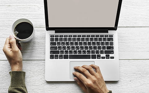 person holding mug while touching MacBook Pro thumbnail