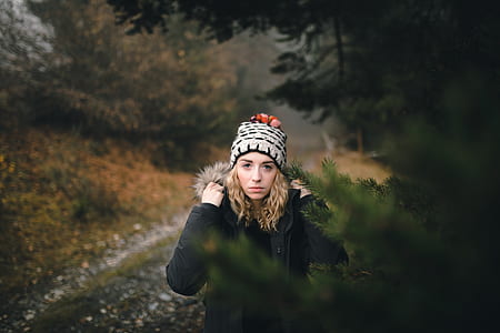 woman walking between tall trees thumbnail