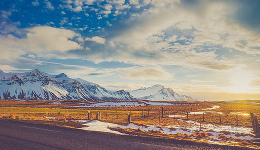 brown field near glacier mountain at daytime thumbnail