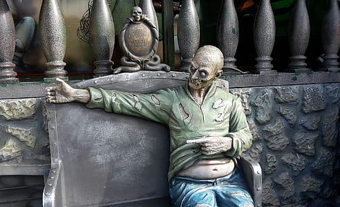zombie sitting on bench in front of grey stone wall thumbnail