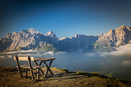 gray wooden table and bench on brown soil thumbnail