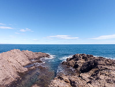 gray rock formation surrounded by water during daytime thumbnail