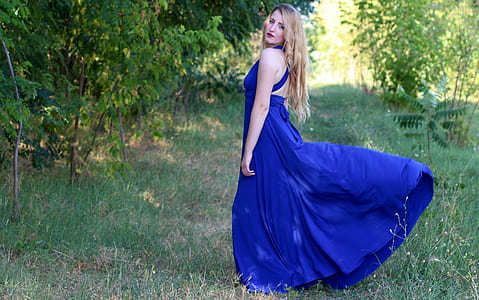 woman wearing blue halterneck sleeveless maxi dress outdoors thumbnail