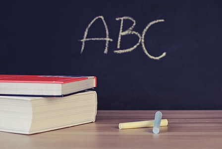 books and chalks on wooden surface thumbnail