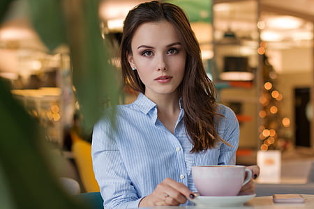 woman in blue shirt holding cup thumbnail