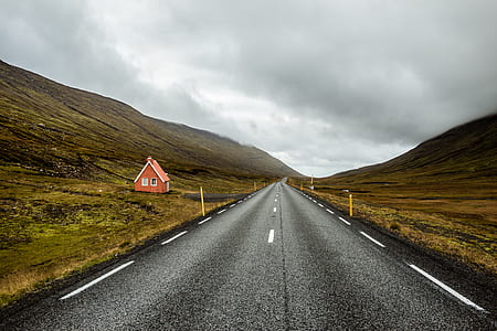 black concrete road between mountains under white and gray sky at daytime thumbnail