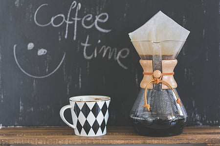 black and white ceramic cup beside clear glass pot thumbnail