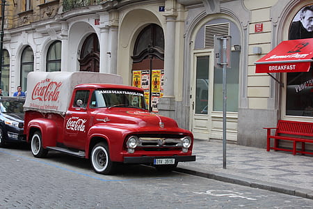 vintage red Coca-Cola parked on front of building thumbnail