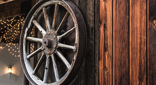 brown carriage wheel hanged on brown wall thumbnail