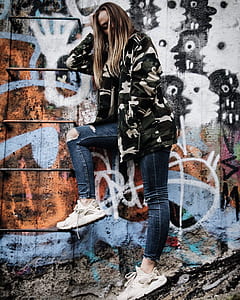 woman leaning on white and black painted wall thumbnail