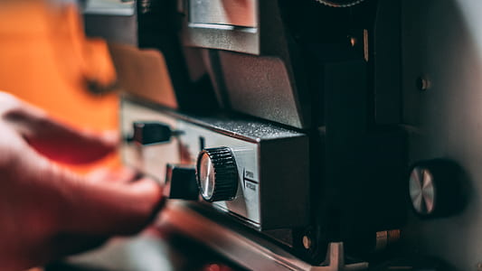 shallow focus photography of person holding black electronic control switch thumbnail