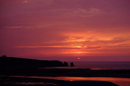 silhouette of island under cloudy sky photo taken during sunset thumbnail