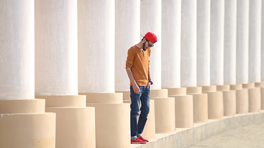 man standing between white pillars thumbnail