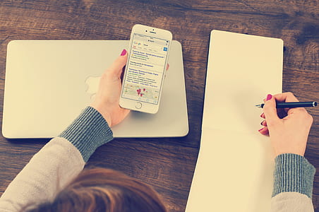 woman holding silver iPhone 6 and black ballpoint pen thumbnail