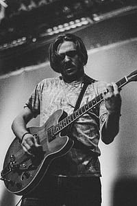 Grayscale Photography of Man Playing Guitar thumbnail