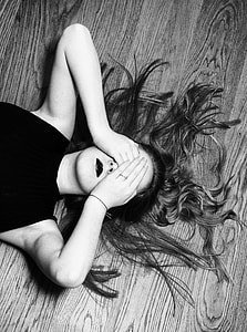 grayscale photography of woman laying on wooden floor thumbnail