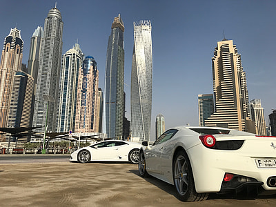 white Ferrari sports car near city buildings during daytime thumbnail