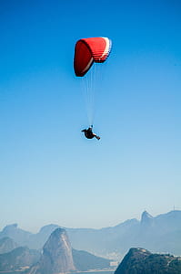 Red White Parachute on Top of Mountains during Daytime thumbnail