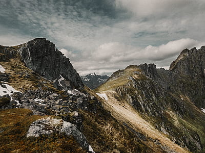 gray and white mountain under cloudy sky thumbnail