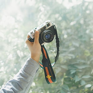 person holding black and silver DSLR camera thumbnail