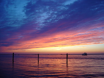 silhouette of boat on body of water thumbnail
