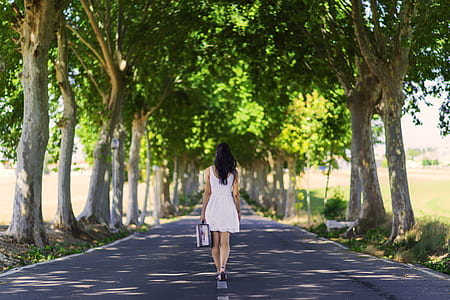 woman in white dress walking on road at daytime thumbnail