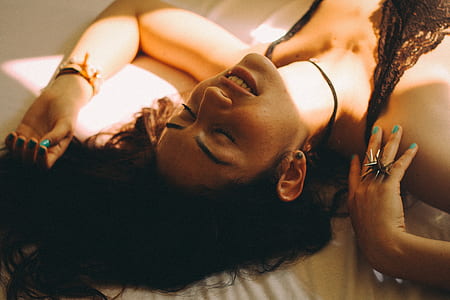woman with lace top lying on bedspread thumbnail