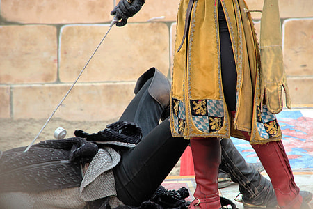 person wearing black leather boots and black pants laying on gray surface during daytime thumbnail