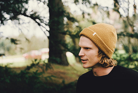 selective focus photography of man standing on forest at daytime thumbnail
