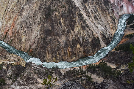 aerial photo of body of water between trees and mountain during daytime thumbnail