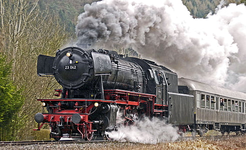 moving black locomotive train covered with thick smoke thumbnail