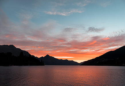 silhouette of mountains surrounded by ocean water thumbnail