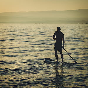 man standing on paddle board thumbnail