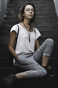 woman sitting on stairs wearing white short-sleeved shirt thumbnail