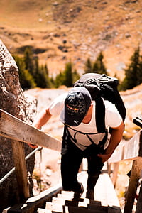 man climbing on brown wooden stairs thumbnail