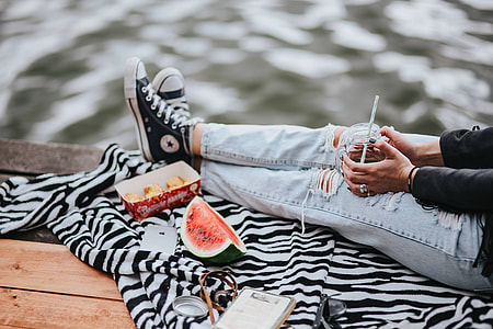Blonde woman having a healthy snack at the wooden pier thumbnail