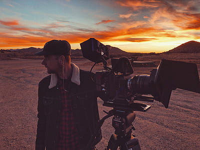 man holding DSLR camera with tripod thumbnail
