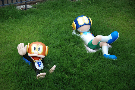 two character statuettes on grass field at daytime thumbnail