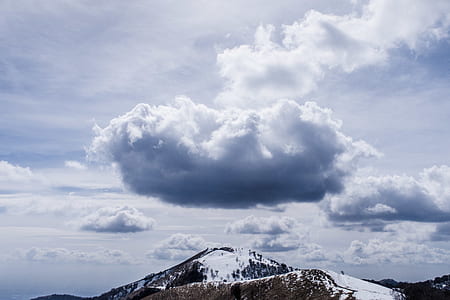 brown and white snowcap under cloudy sky at daytime thumbnail