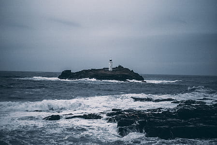 white light tower on island in ocean thumbnail