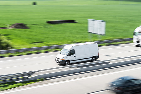 White Delivery Van in Motion Driving on Highway thumbnail